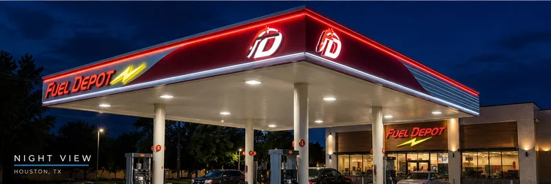 The same Fuel Depot canopy at night with the fascia color band, logo signs and store sign all illuminated over the lit pump islands